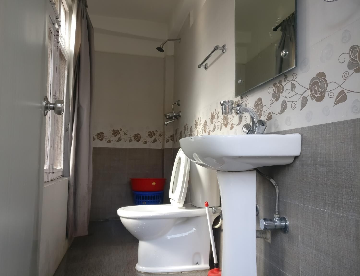 Ein Badezimmer mit Toilette, Waschbecken, Dusche und Spiegel.