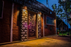 A building with a brick facade, decorative panels, and a hanging chair in the outdoor area.