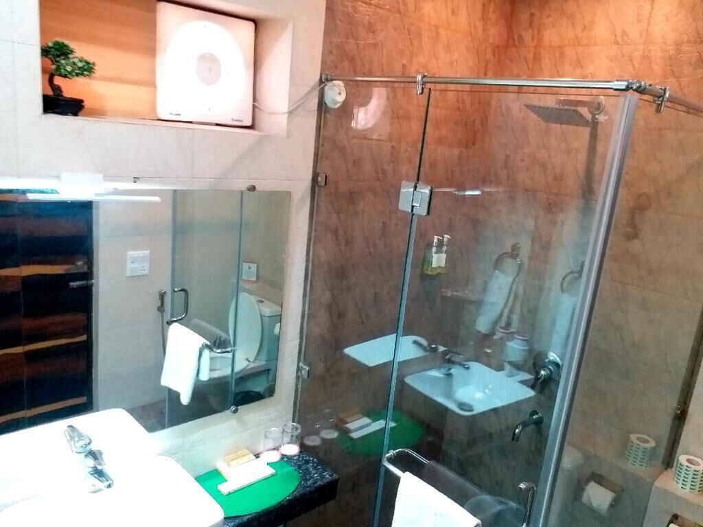 Une salle de bain moderne avec une douche à parois de verre, un grand miroir et un lavabo.