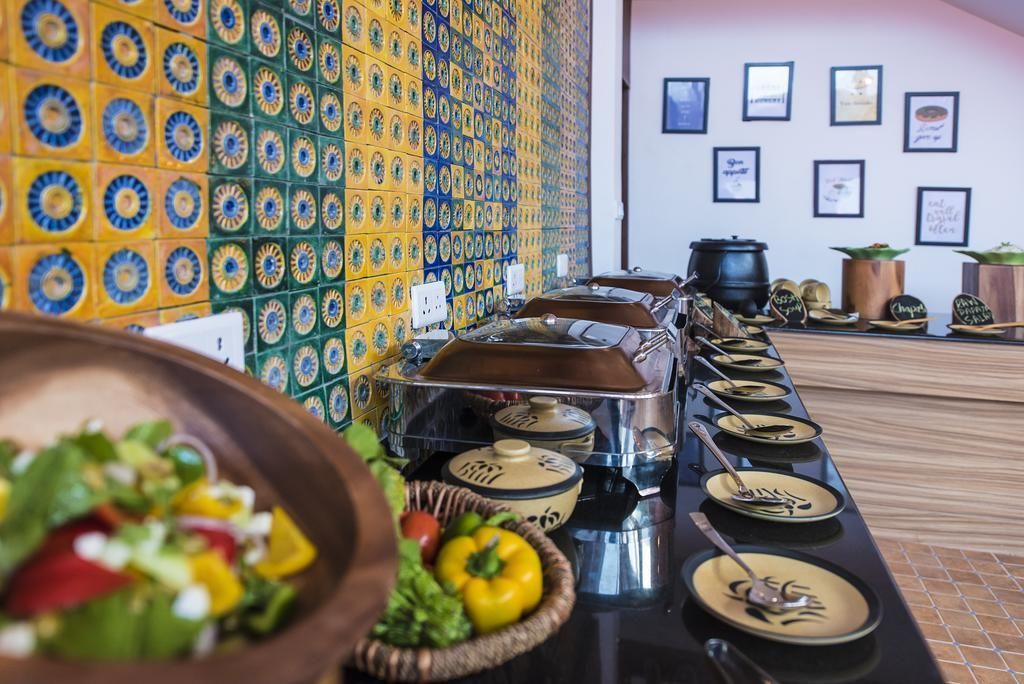 Ein reichhaltiges Buffet mit verschiedenen Speisen und einer Wand mit dekorativen Fliesen.