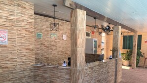A reception area with a modern design, featuring a reception desk, a fire extinguisher, and a sign indicating a no smoking policy. - Pousada Mar do Sonho (Ipojuca)