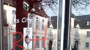 A hotel entrance with a glass door, a red 'R' sticker, and a sign reading "Ricks City Hotel". - Ricks City Hotel 2 (Trier)