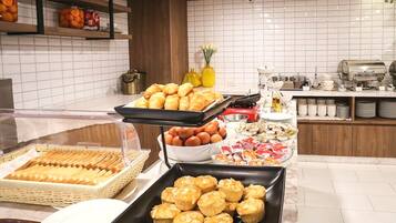 Un bufé con diversos alimentos, incluyendo pasteles, huevos y salsas.