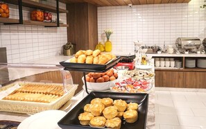 A buffet with various food items including pastries, eggs, and condiments.