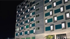 A multi-story hotel with a pool area in the foreground. - Sann Hotel (Chiang Rai)