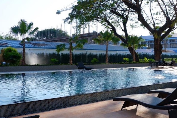 Alberca al aire libre, sombrillas en la alberca y camastros