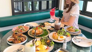 A dining table with various dishes, including seafood, salads, and a drink. - Sann Hotel (Chiang Rai)