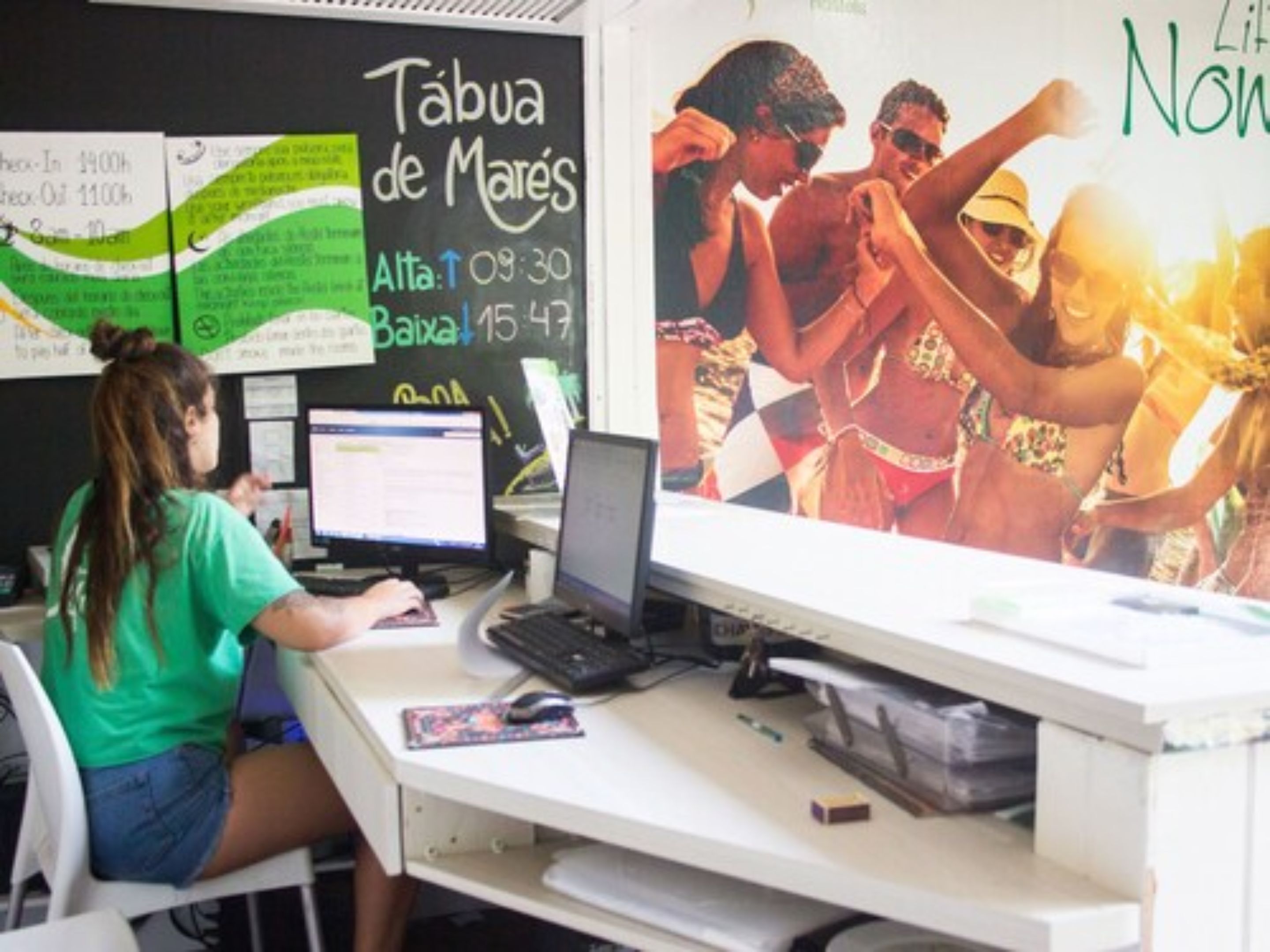Un espacio de trabajo con una computadora, un escritorio y una pizarra con texto e ilustraciones.