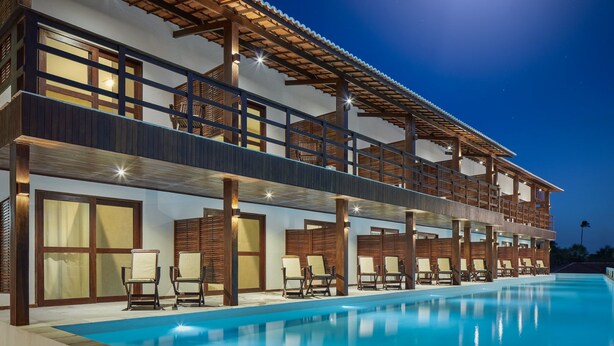 A two-story building with a swimming pool, outdoor seating, and a balcony. - Rox by Essenza Hotel (Jijoca de Jericoacoara)