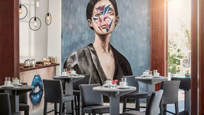 A modern dining area with round tables, chairs, and a large abstract painting on the wall. - Rox by Essenza Hotel (Jijoca de Jericoacoara)