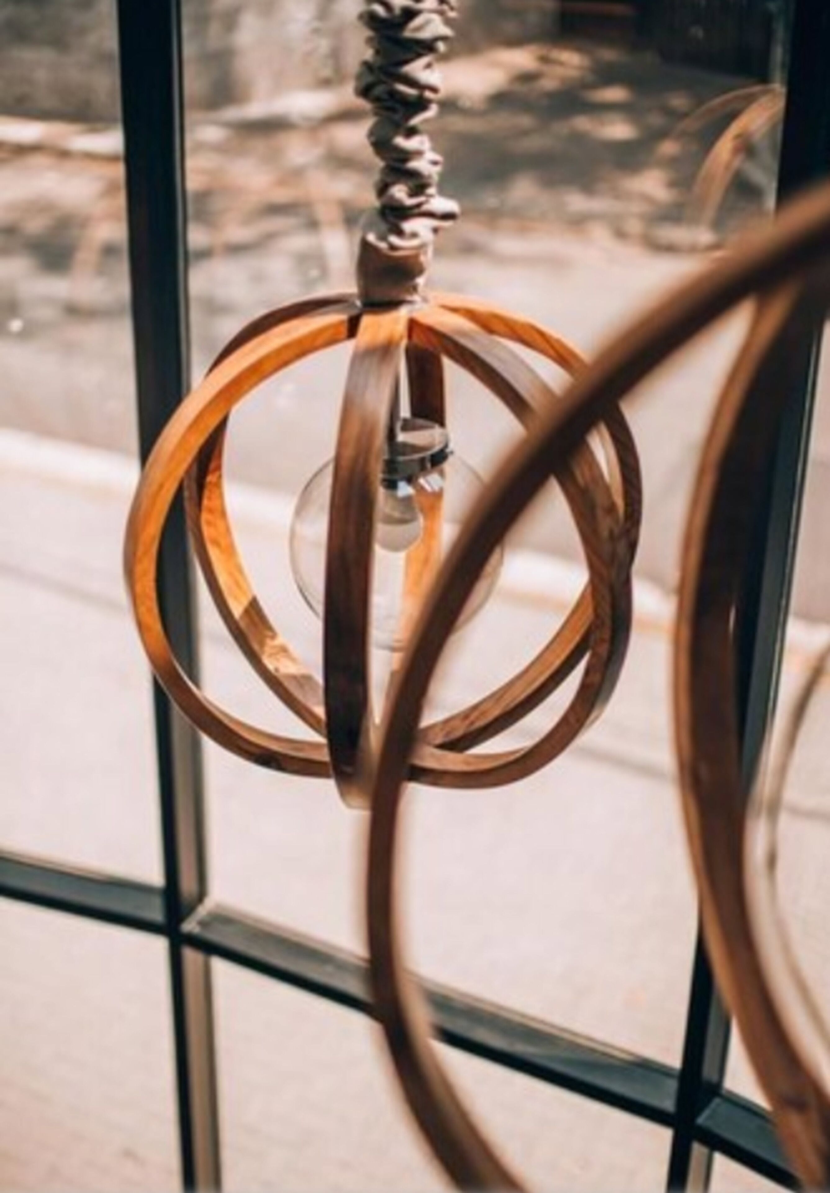 A hanging light fixture with a twisted metal design.
