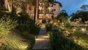 A multi-story building with a stone pathway leading to a gated entrance. - Villa Amistà Campos do Jordão (Campos do Jordão)