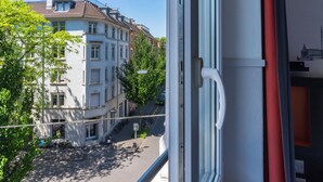 A view from a window overlooking a street with buildings, a bicycle, and a clear sky. - easyHotel Zürich City Limmatplatz (Zürich)