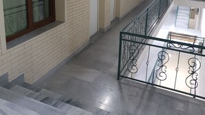 A corridor with tiled walls, a metal railing, and a ceiling with a skylight. - Hotel Khiva (Tashkent)