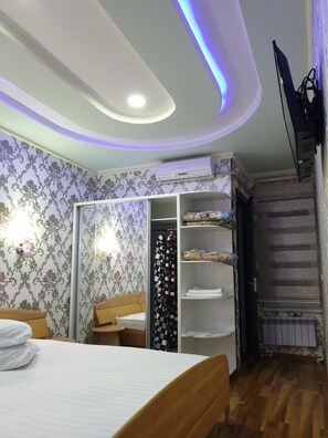 A bedroom with a bed, wardrobe, and a radiator.