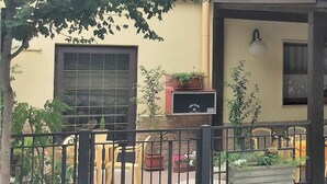 A hotel with a covered outdoor seating area, potted plants, and a visible entrance. - Hotel Viola (Caramanico Terme)