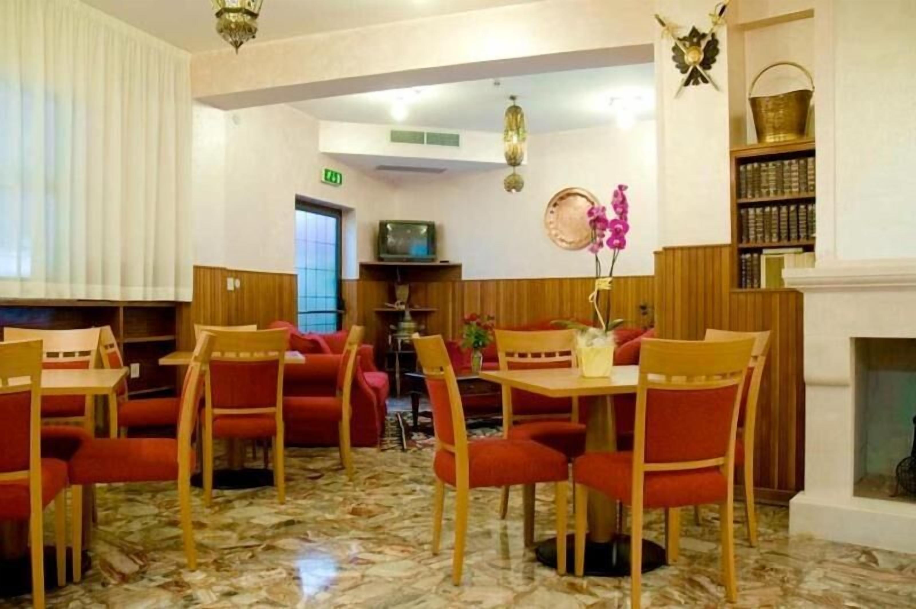 Una hall d'albergo con un camino, una televisione e una libreria.