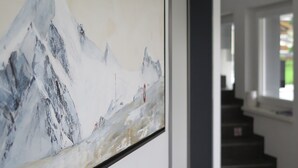 Quadro com paisagem de montanha emoldurada pendurado na parede.