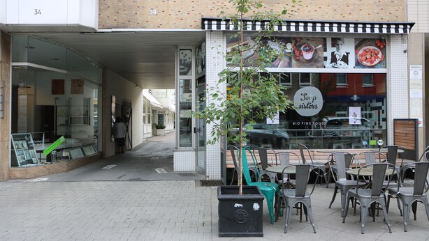 A cafe with outdoor seating, a sign reading "Soup Sisters," and a storefront with glass doors. - Apartment Osterstraße 321 (Hannover)