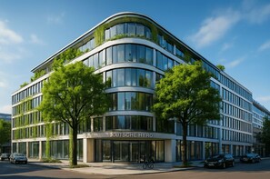 Un edificio moderno con arquitectura curvilínea, ventanas amplias y vegetación en la fachada.