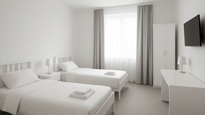 Une chambre d’hôtel avec deux lits, un bureau, une télévision et une armoire.