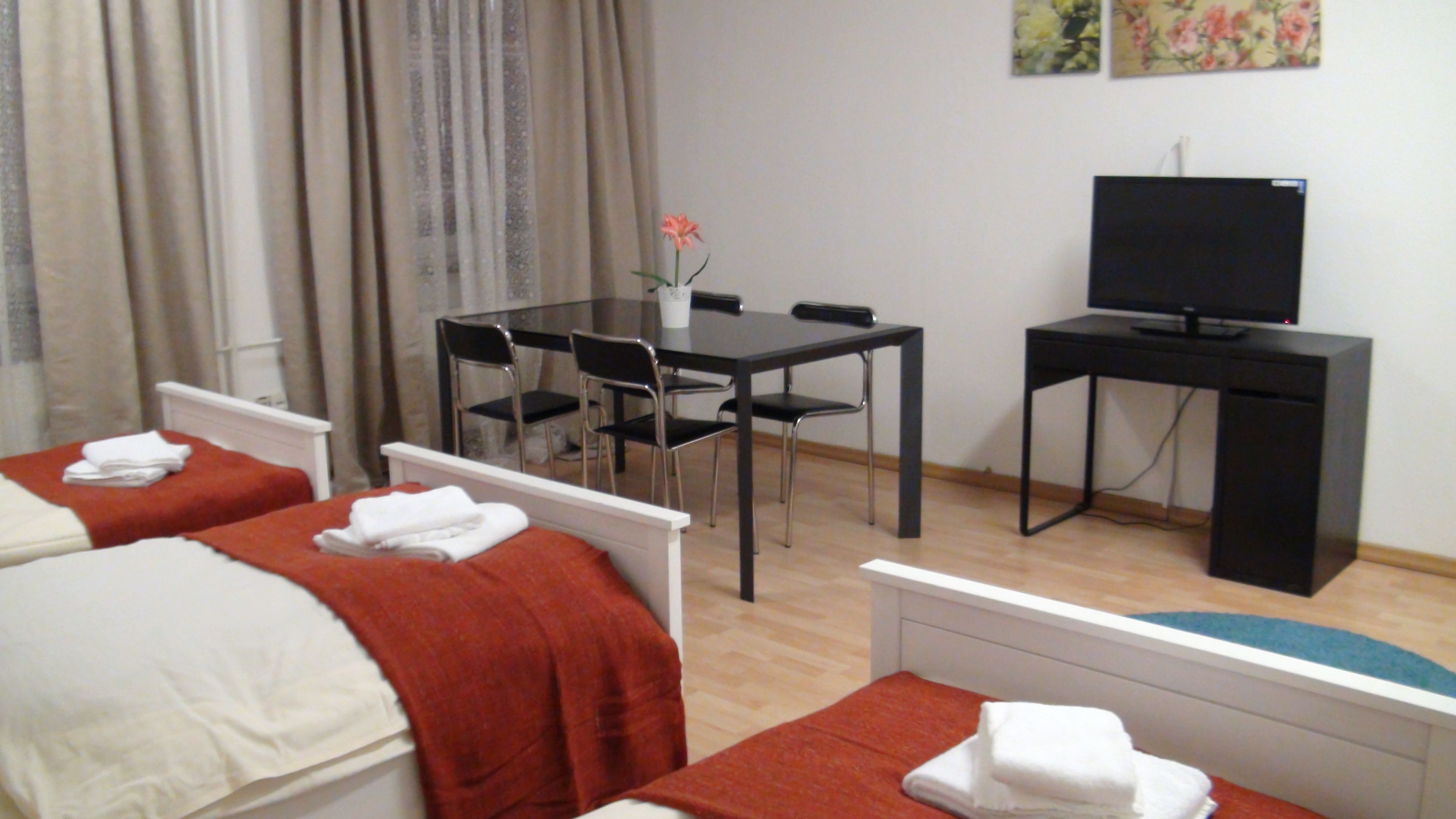 Een hotelkamer met twee bedden, een bureau, een stoel en een televisie.