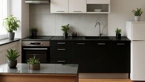 A modern kitchen with black cabinets, a stainless steel range, and a white refrigerator. - Apartment Osterstraße 322 zwei (Hannover)