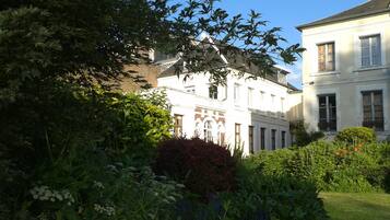 A two-story building with a garden in front.