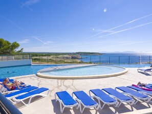 A pool area with blue lounge chairs and a view of the sea. - Lagrange Vacances Camping de l'Arquet (Martigues)