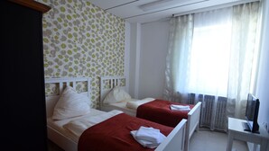 A hotel room with two beds, a TV, and a window with curtains. - Apartment Osterstraße 324 zwei (Hannover)