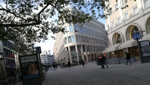A public square with modern buildings, a large advertisement board, and a few pedestrians. - Apartment Osterstraße 324 zwei (Hannover)