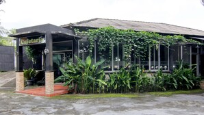 A building with a sign reading "Cafetaria" and a covered entrance area with potted plants. - Hotel Popi Pondok Pisang (Ngaglik)