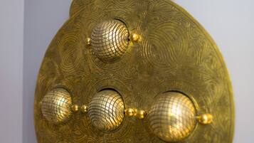 A decorative brass object with intricate patterns and spherical elements.