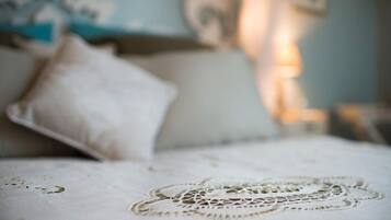 Un lit avec un chemin de table en dentelle et un oreiller.