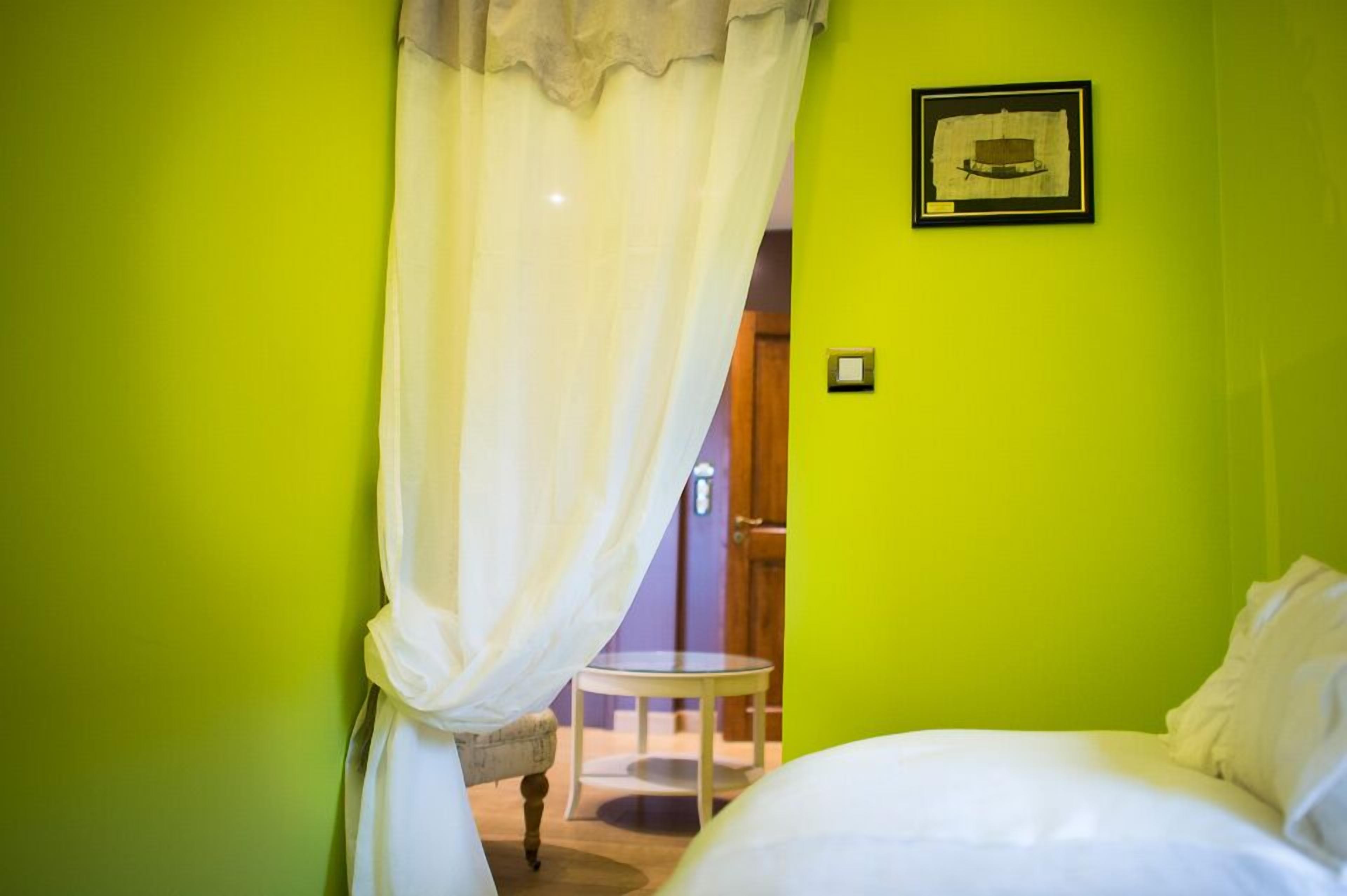 A room with a bed, a small round table, and a chair.