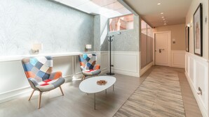 A modern hotel lobby with two armchairs, a coffee table, and a large window. - Serennia Fira Gran Vía Exclusive Rooms (L'Hospitalet de Llobregat)