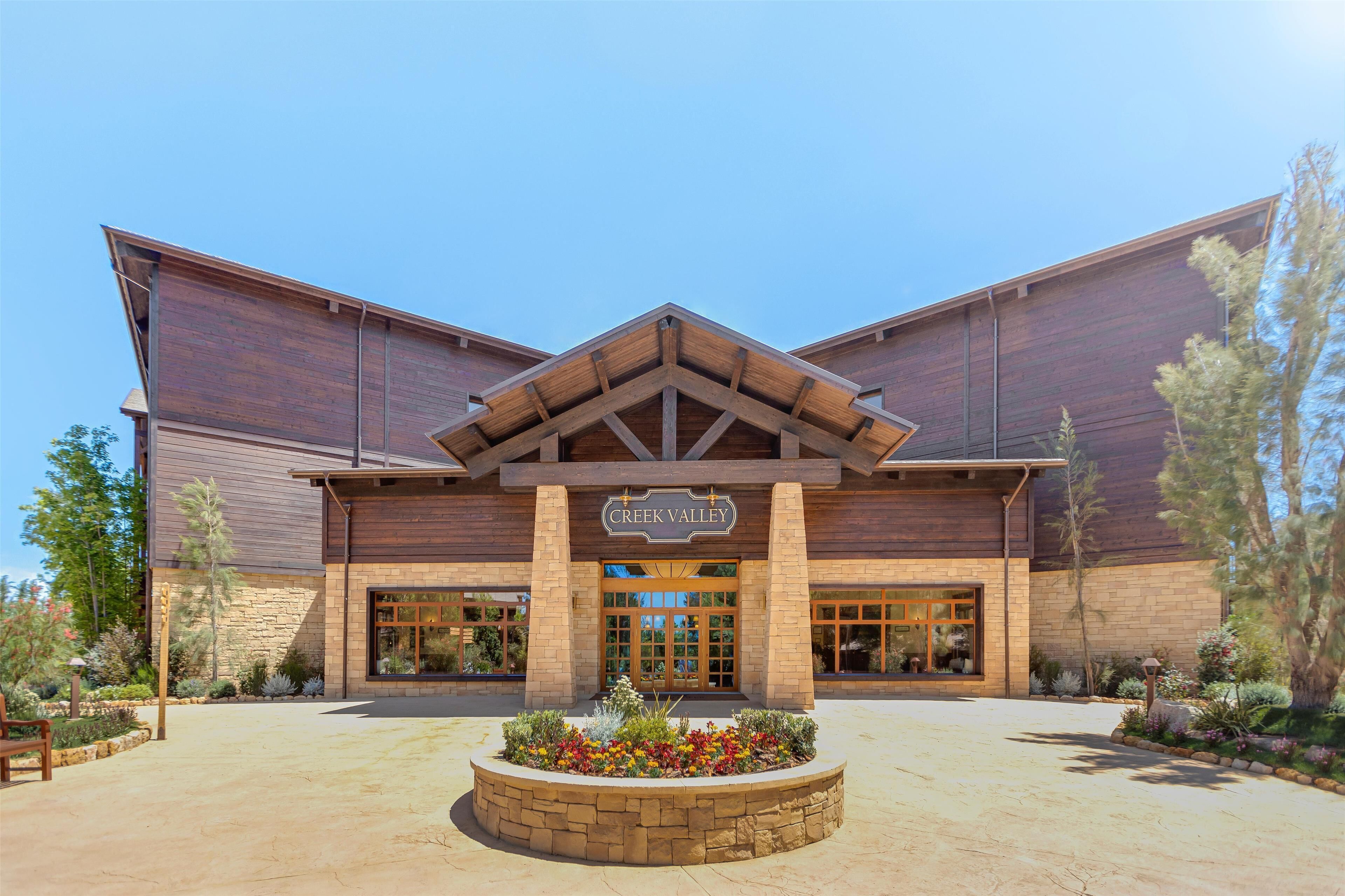 A modern building with a wooden facade and a sign reading "Creek Valley."