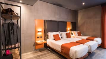Ein Hotelzimmer mit zwei Betten, einem Kleiderschrank und einem Nachttisch mit Lampe.