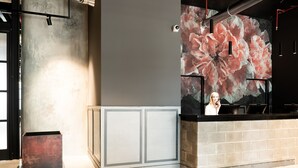 A reception area with a large floral mural, a reception desk, and a metal column. - J24 Hotel Milano (Milan)