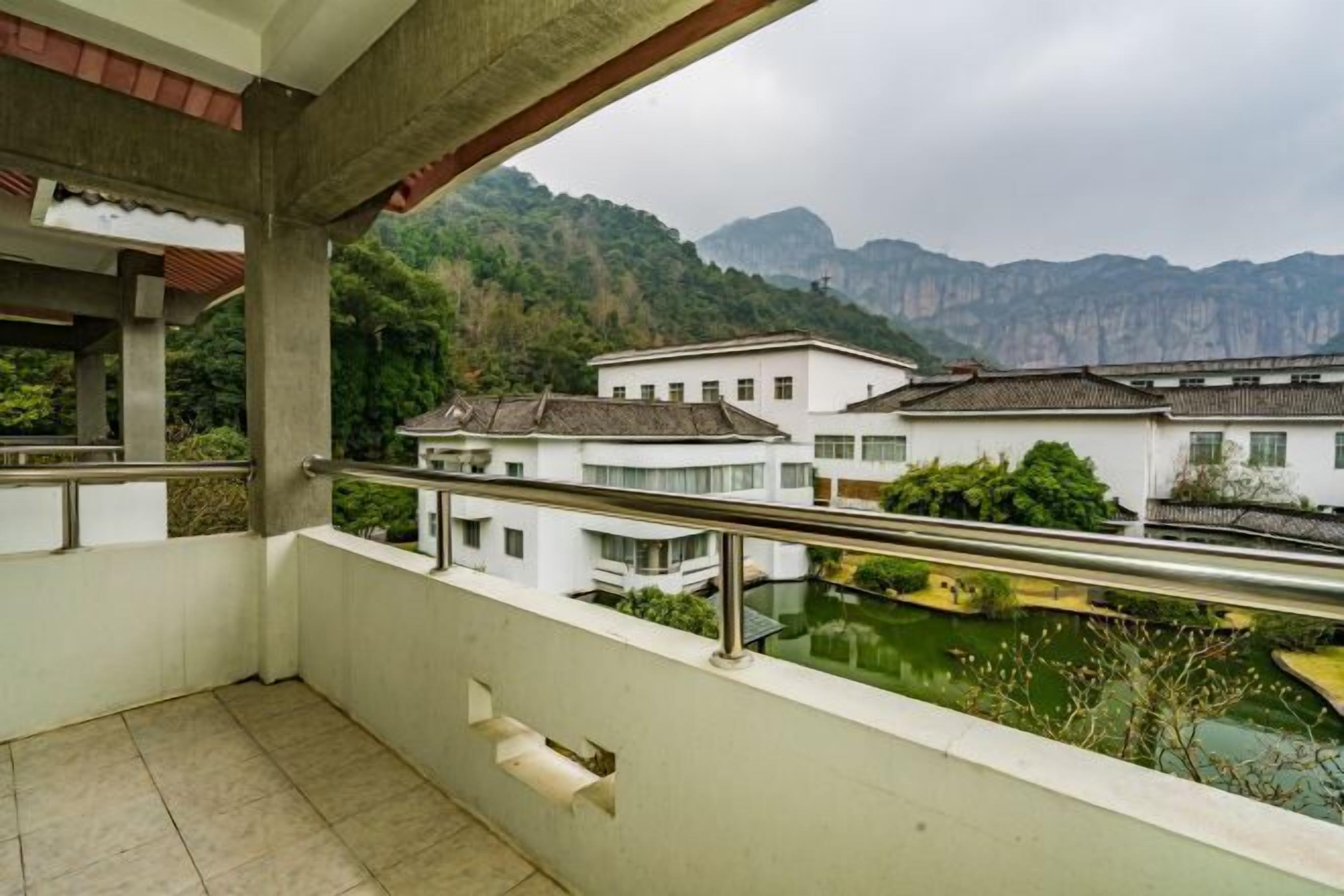 Un balcon offrant une vue sur des bâtiments traditionnels et une rivière.