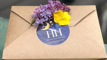 A brown cardboard box with a circular sticker featuring the logo and name of Highland Haven Creekside Inn.