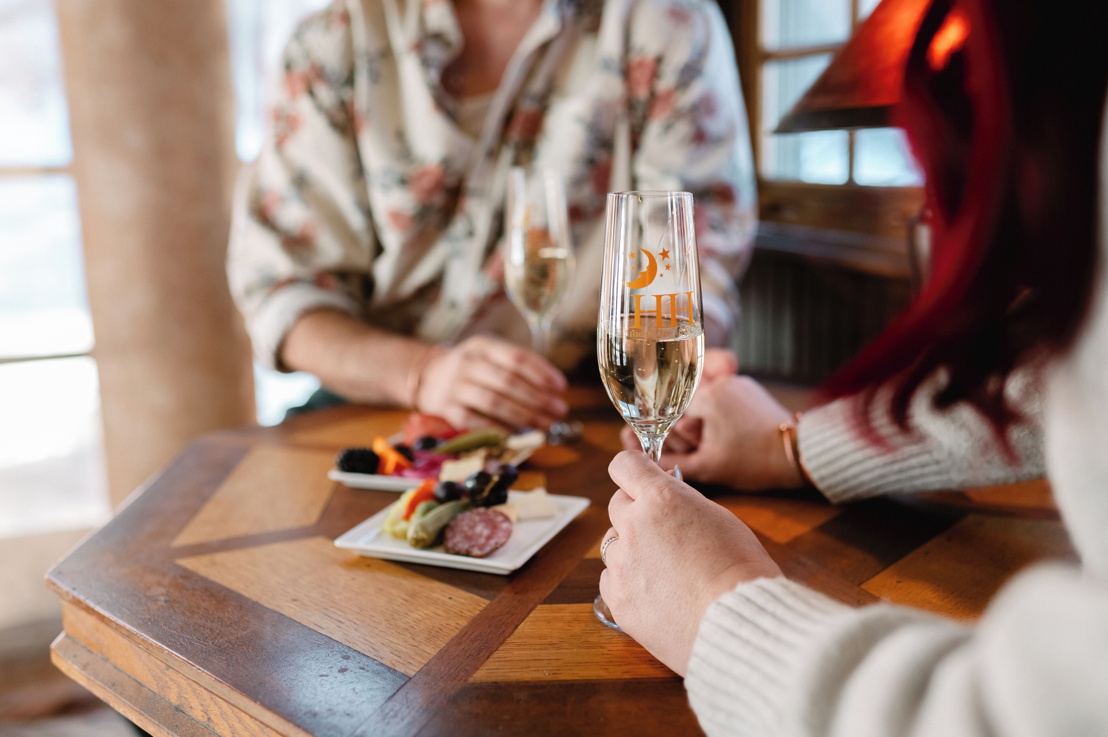 A wooden table with a plate of food and a glass of wine.