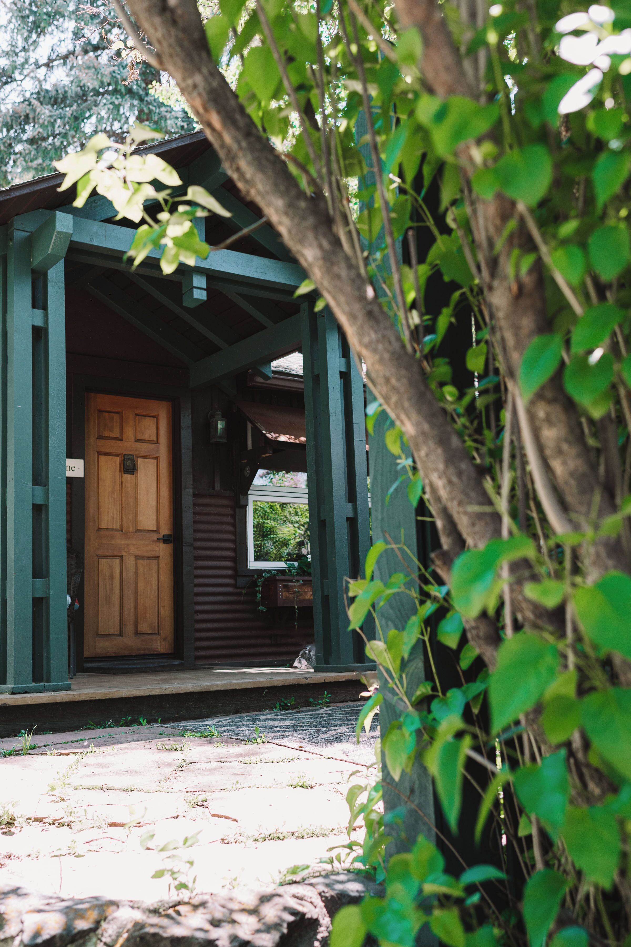 A wooden door with a window and a porch.