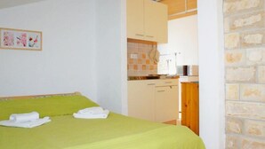 Una habitación con cama, kitchenette pequeño y baño.