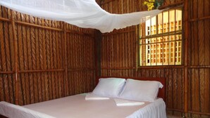 A room with a bed, white curtains, and a window with a grid pattern. - Phuong Thao Homestay (An Binh)