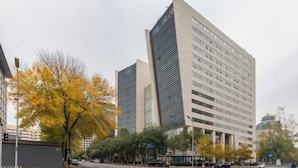 Een modern gebouw met een opvallend hoekontwerp, met meerdere verdiepingen en grote ramen.