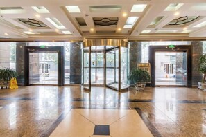 A hotel lobby with a revolving door, large windows, and a polished marble floor. - CY Journalists' Home Hotel（Dongzhimen Hospital Dongsishitiao Subway Station Branch） (Beijing)