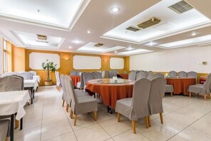 A conference room with round tables and chairs, a large plant, and a whiteboard. - CY Journalists' Home Hotel（Dongzhimen Hospital Dongsishitiao Subway Station Branch） (Beijing)
