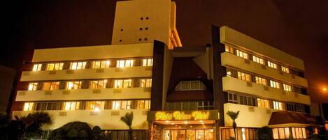 A hotel with a central entrance, multiple floors, and a prominent tower.