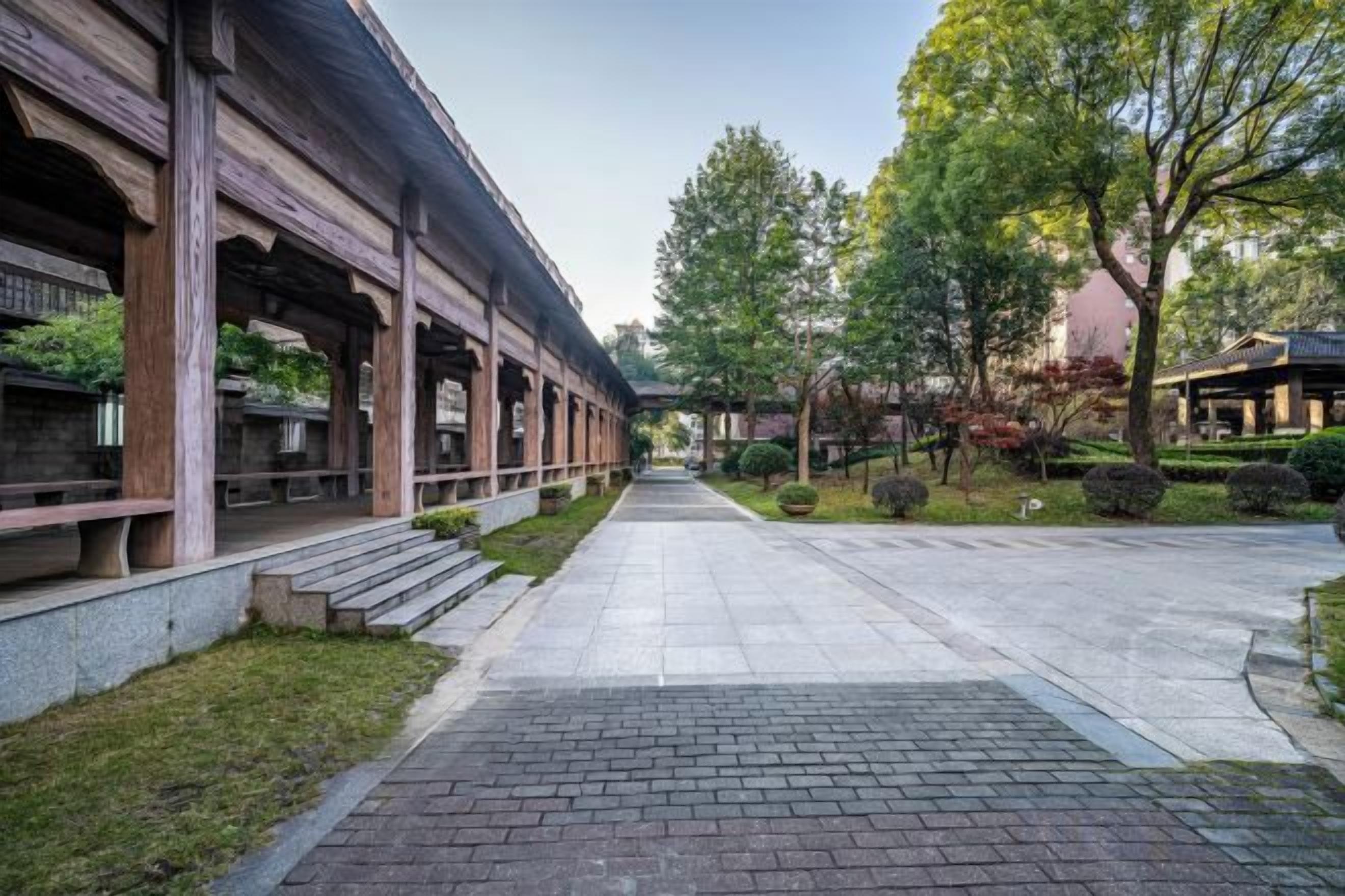 A traditional building with a covered walkway and steps leading to a door.